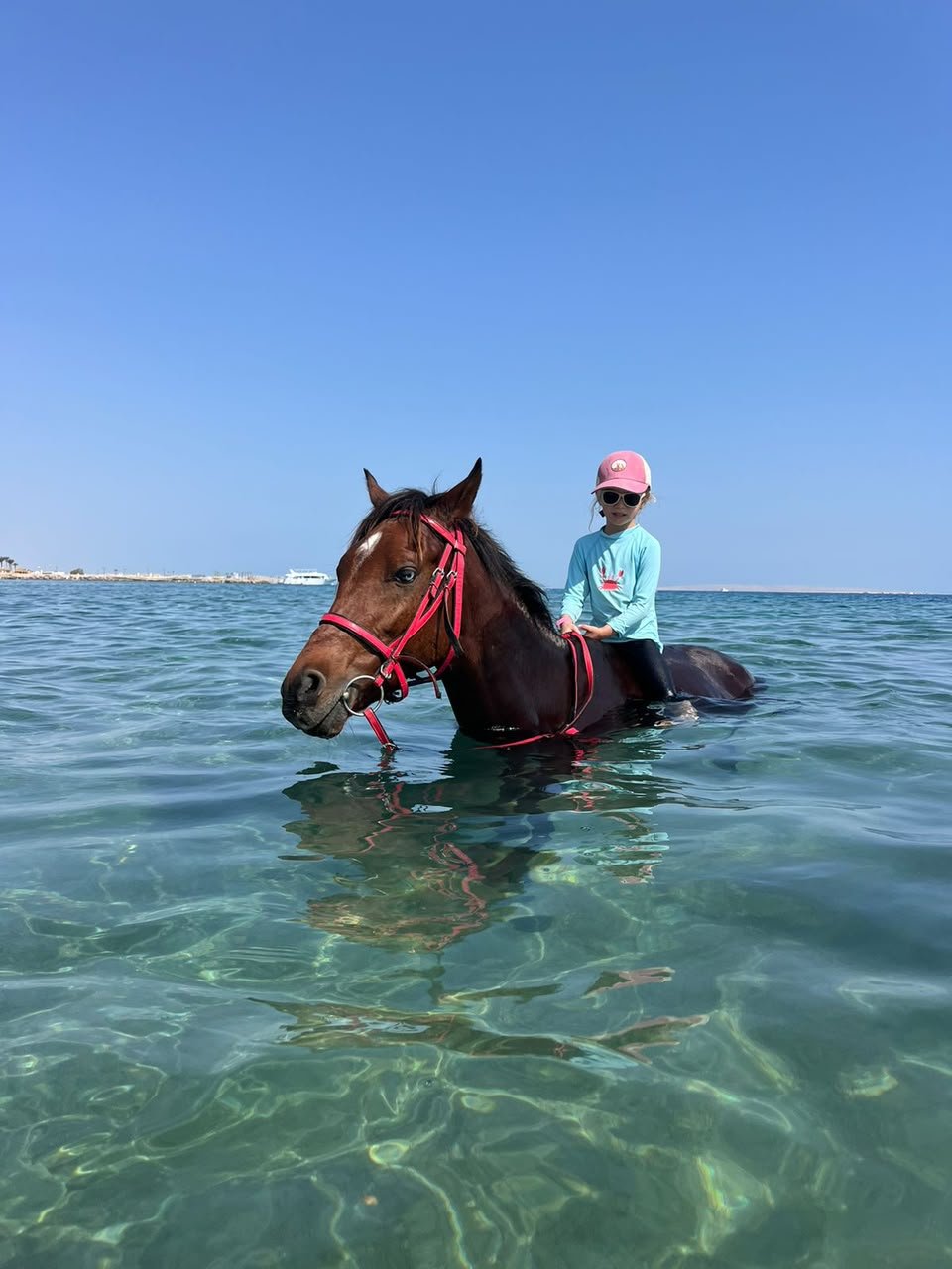 Kind reitet mit Pferd im Wasser bei Hurghada